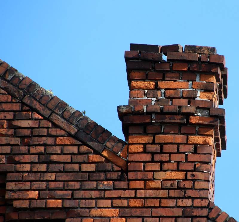 Signs Your Arlington Home Needs a Chimney Inspection Blog Article - Damaged chimney on an Arlington home showing cracks and missing mortar